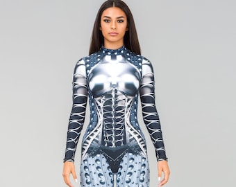 May include: A woman wearing a blue and silver jumpsuit with a metallic design. The jumpsuit has a corset-like bodice and a textured pattern on the legs.