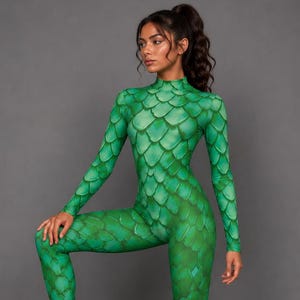 Könnte beinhalten: Ein langärmeliger Jumpsuit mit Stehkragen und einem durchgehenden grünen Drachenschuppenmuster. Das Kleidungsstück ist körperbetont geschnitten und bedeckt den Körper vom Hals bis zu den Knöcheln mit einem sich wiederholenden Schuppenmuster.