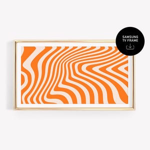 Könnte beinhalten: Ein gerahmter Kunstdruck mit einem abstrakten Design aus orangefarbenen und cremefarbenen Wellenlinien. Das Kunstwerk befindet sich in einem goldenen Rahmen und ist mit "SAMSUNG TV FRAME" in einem schwarzen Kreis versehen.