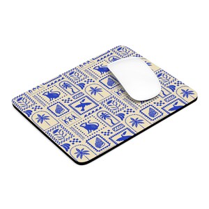 May include: A rectangular mouse mat featuring a cream background with a repeating blue pattern of animals, plants, and geometric shapes. A white computer mouse is on the mat.
