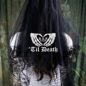 May include: Black wedding veil with lace trim and a white skeleton hand design that says "K & A 2.14.25 'Til Death"