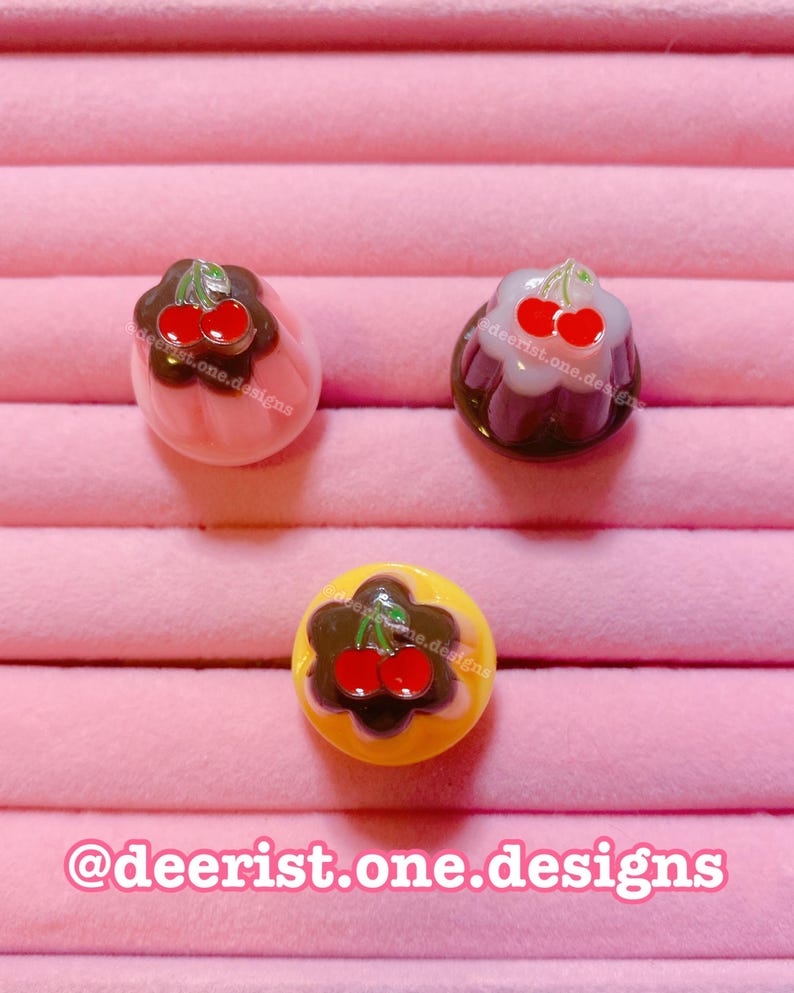 Op de afbeelding: Een set van drie keramische mokken met een gespikkelde, matte afwerking. De mokken zijn in tinten cr&egrave;me, lichtgrijs en donkergrijs. Elke mok heeft een eenvoudig, minimalistisch ontwerp, perfect voor koffie of thee.