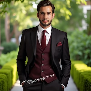 Puede incluir: Un traje negro con chaleco, corbata y pañuelo de bolsillo burdeos. El traje se combina con una camisa blanca. La imagen muestra a un hombre con vestimenta formal, ideal para bodas o eventos especiales.