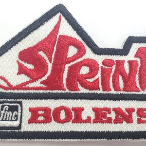 May include: Red embroidered patch with the word "Sprint" in a stylized font and the text "Bolens" below. The patch has a black border and a small white square with the text "Inc" in black.