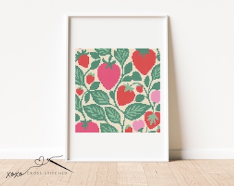 May include: Framed cross-stitch art with a strawberry design. The pattern includes red and pink strawberries and green leaves on a cream background. The artwork is in a white frame. The text "xoxo CROSS-STITCHED" is at the bottom.