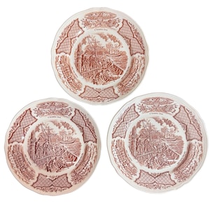 May include: Set of three white ceramic plates with a red and white design. Each plate features a scene of a ship and people on a dock. The plates have a decorative border with a repeating pattern.