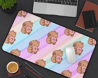 May include: A colorful mousepad with a repeating pattern of cartoon capybaras holding pink donuts. The background is a gradient of pink, blue, and purple stripes.