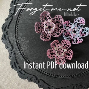 Puede incluir: Tres delicadas flores de nomeolvides de ganchillo en tonos rosa y azul, adornadas con cuentas de perlas y brillantes pedrería. Las flores se muestran sobre un fondo negro con el texto "Forget-me-not" y "LillianTatLace".