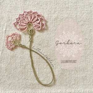 May include: A delicate tatting lace bookmark featuring two pink floral motifs connected by a thin, light brown thread stem. The design includes the text Gerbera and LILLIANTATLACE printed on the fabric background near the lace ornament.
