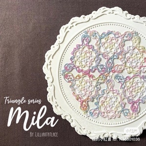 May include: A white plate with a decorative border, featuring a colourful lace design in shades of pink, blue, and yellow. The lace design is arranged in a geometric pattern, creating a visually appealing and intricate piece. The text "Triangle series Mila by LILLIANTATLace" is visible below the plate.