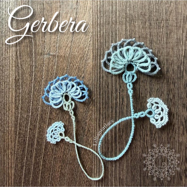 May include: Two delicate tatting lace bookmarks in shades of light blue and white. Each bookmark features a fan-shaped floral motif at the top, a long thin stem, and a smaller decorative fan-shaped element at the bottom end of the thread loop.