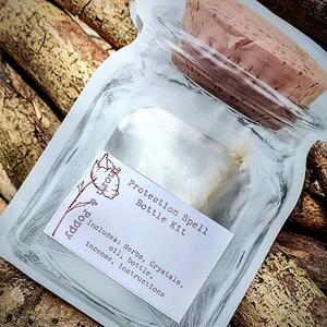 May include: A clear glass bottle with a cork stopper, packaged in a white plastic bag. The bottle is labeled "Protection Spell Bottle Kit" and includes the text "Includes: Herbs, Crystals, oil, bottle, incense, instructions".