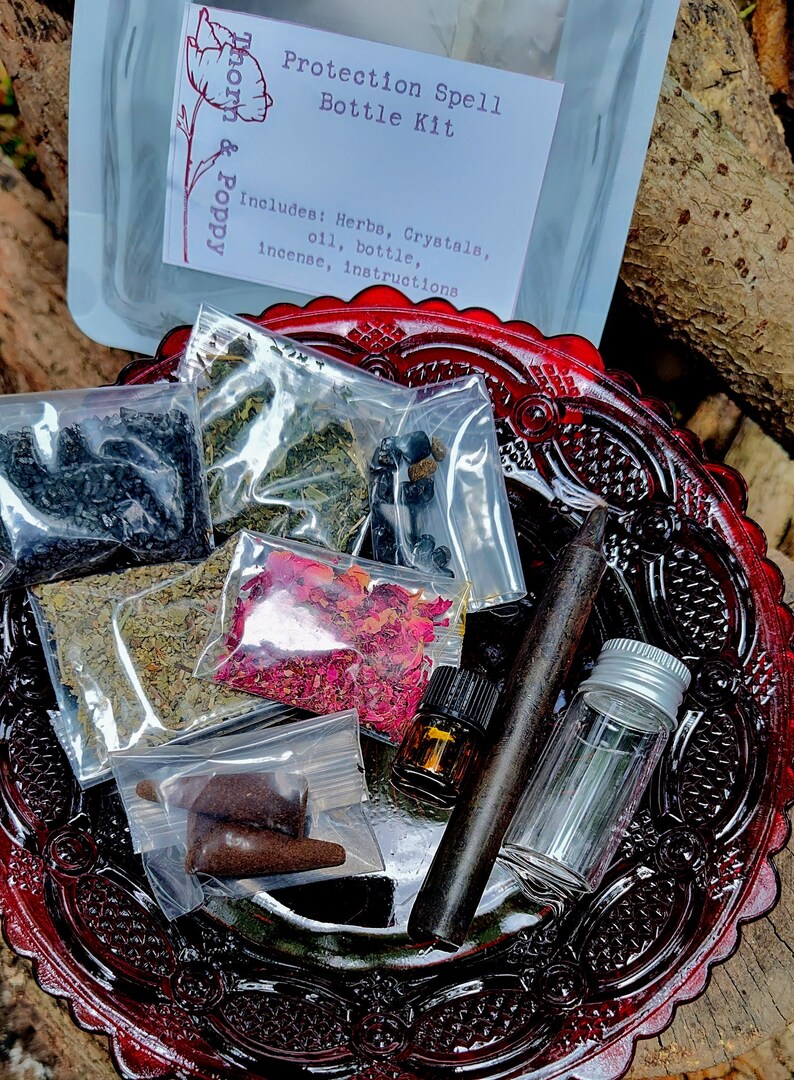 May include: A red glass plate with a protection spell bottle kit. The kit includes herbs, crystals, oil, a bottle, incense, and instructions. The kit is packaged in clear plastic bags.