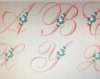 May include: Six embroidered letters, A, B, C, X, Y, and Z, in a cursive font with pink thread and blue floral accents.