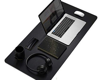 May include: A black desk mat with a laptop, mouse, smartphone, notebook, headphones, and a mug. The laptop is open, displaying a website. The notebook has a gold glitter design. The headphones are over-ear.