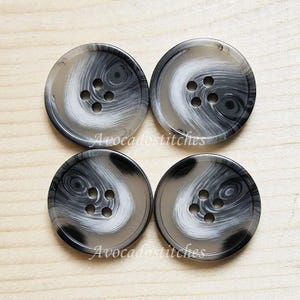 May include: Four black and white swirl patterned buttons with four holes each.