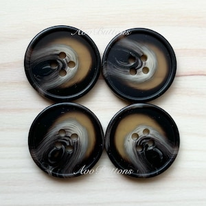 May include: Four black and brown swirl patterned buttons with four holes each. The buttons are arranged in a square shape.
