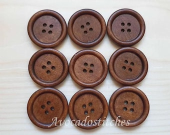 May include: Ten brown wooden buttons with four holes each. The buttons are arranged in three rows, with three buttons in the top row, three buttons in the middle row, and four buttons in the bottom row.