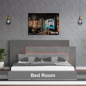 May include: A gray upholstered bed with a headboard and a gray bedspread. The bed is in a room with a gray wall and a framed picture of a bookstore interior. The picture is labeled "24x36".