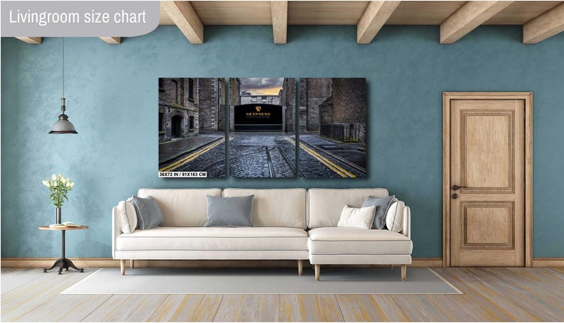 May include: A three-panel canvas print depicting a narrow street in a city. The street is lined with brick buildings and has a cobblestone surface. The middle panel features a large, arched doorway with the text "GUINNESS" above it.