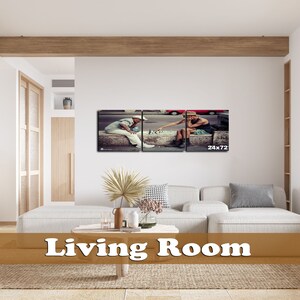 May include: A living room with a white couch and a brown wooden coffee table. A framed print of two people playing chess on a sidewalk is hanging on the wall. The print is divided into three sections and the text "24x72" is printed in the bottom right corner.