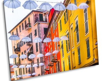 Può includere: Una scena di strada colorata con file di edifici dai colori vivaci. Ombrelloni bianchi sono appesi sopra la strada, creando un'atmosfera fantasiosa e festosa.
