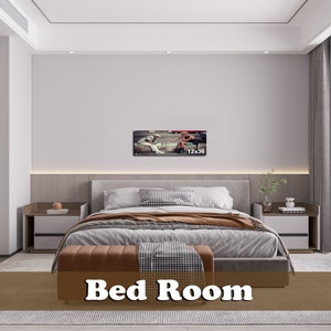 May include: A modern bedroom with a large bed, two nightstands, and a framed photograph of two people playing chess. The bed has a gray headboard and a brown and white patterned comforter. The nightstands are made of wood and have white drawers. The photograph is in a black frame and is hanging on the wall above the headboard. The room has a white ceiling and white walls. The floor is covered in a brown rug.