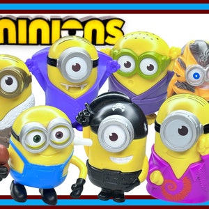 Op de afbeelding: Een set van zeven gele Minion-speelgoedfiguren, elk met een ander kostuum. De Minions dragen kostuums zoals een paarse vampier-outfit, een zwarte piraten-outfit, een bruine winterjas, een blauwe overall, een paarse ninja-outfit, een paarse karate-outfit en een paarse disco-outfit. De Minions lachen allemaal en hebben grote, ronde ogen.