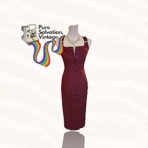 May include: A maroon midi dress with a button-up front and a fitted silhouette. The dress has a square neckline and thin straps. The dress is on a mannequin with a pearl necklace.