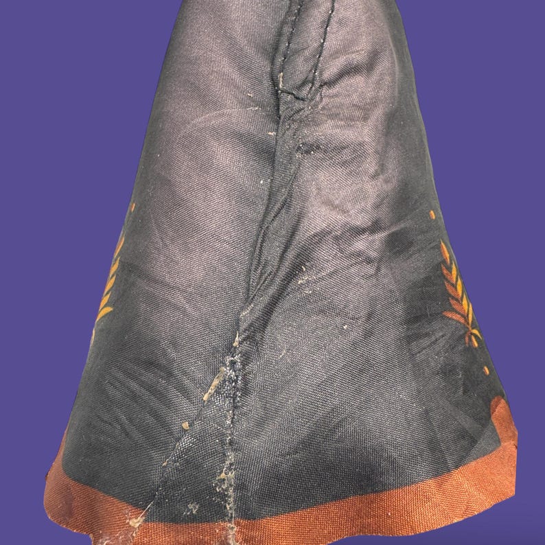 Close-up of back of skirt fabric showing mended tear repair with visible stitching on original dress