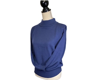 May include: A blue mock neck sweater with long sleeves. The sweater is on a mannequin.