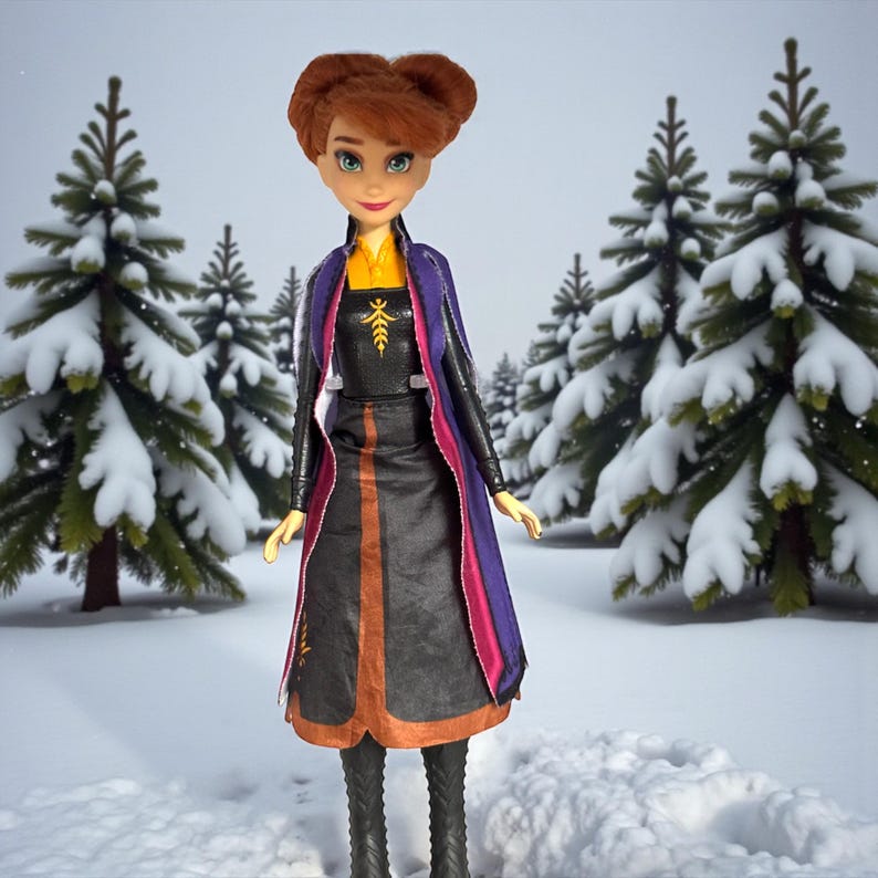 Full-length front view of Anna Frozen II doll standing upright showing autumn leaf dress design and tall black boots