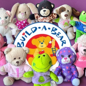 Puede incluir: Una colección de peluches Build-A-Bear Workshop, que incluye un mono rosa, un oso marrón, un oso morado, un conejito blanco, un cordero blanco, un perro marrón, una rana verde y un caniche rosa. Todos los peluches llevan diferentes atuendos y tienen diferentes expresiones en sus caras.