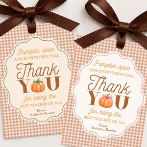 Può includere: Due etichette regalo rettangolari con motivo a quadretti marrone chiaro, ciascuna sormontata da un fiocco in nastro di raso marrone scuro. Le etichette presentano un cartellino bianco smerlato con il testo Pumpkin spice and everything fall Thank YOU for being the BEST TEACHER OF ALL From: Autumn Brown e una piccola illustrazione di zucca arancione.