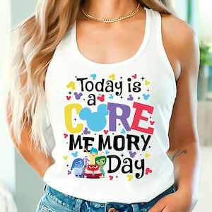 May include: White tank top with a colorful graphic that says "Today is a CORE MEMORY Day" with a Mickey Mouse head inside the "O" and characters from the movie Inside Out.