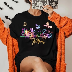 Neon Halloween shirt featuring glow-in-the-dark skeletons, ghosts, and a witch, perfect for spooky parties and Halloween celebrations.