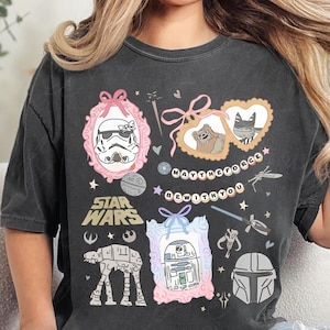 Retro pastel water color coquette Star Wars shirt with kawaii-style Stormtrooper, R2D2, AT-AT, Ewok, and Mandalorian helmet in watercolor frames with bows and hearts, perfect for Disney trip or Star Wars Day outfit.