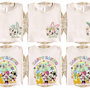 May include: Six white t-shirts featuring Easter-themed Disney characters. Three shirts depict Mickey Mouse, Minnie Mouse, and Goofy wearing bunny ears and surrounded by Easter eggs. The remaining three shirts display the text "Happy Easter" within a colourful circle containing Mickey Mouse, Minnie Mouse, Donald Duck, Goofy, Pluto, and Daisy Duck.