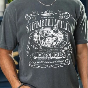 Vintage Steamboat Willie shirt featuring classic black and white Mickey Mouse steering a ship wheel, retro Disney cartoon design, perfect for Magic Kingdom trips, Disney family vacation outfits, or nostalgic Mickey Mouse birthday gifts for adults and kids.