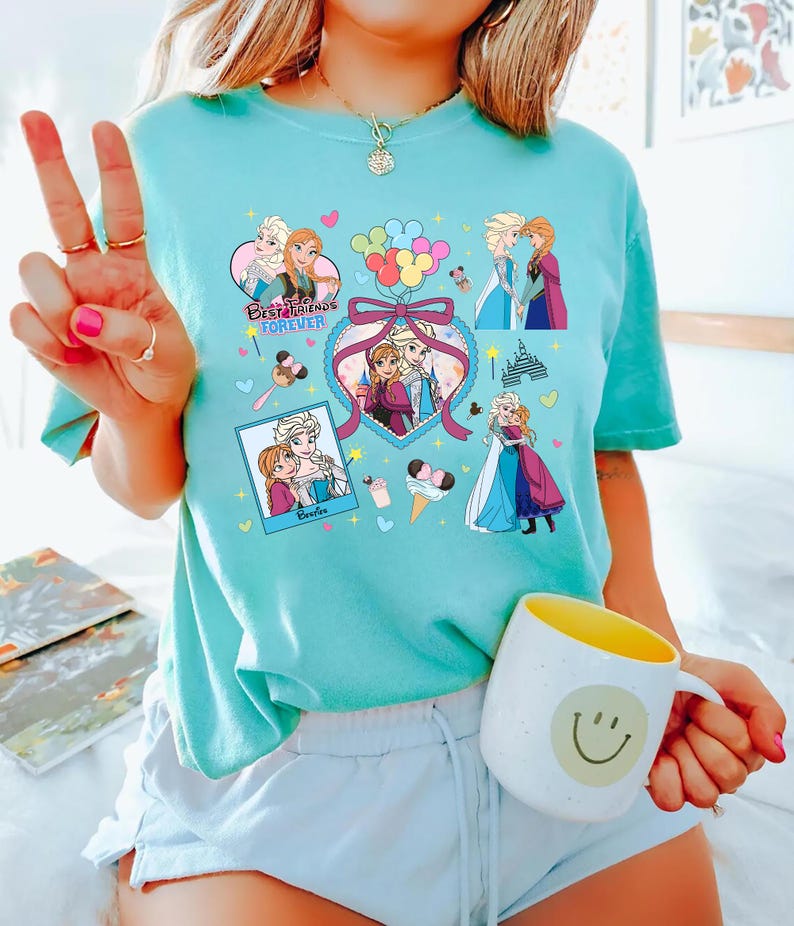 Cute coquette-style Disney Frozen shirt featuring Elsa and Anna with hearts, bows, and pastel icons, ideal for sisters and best friends.