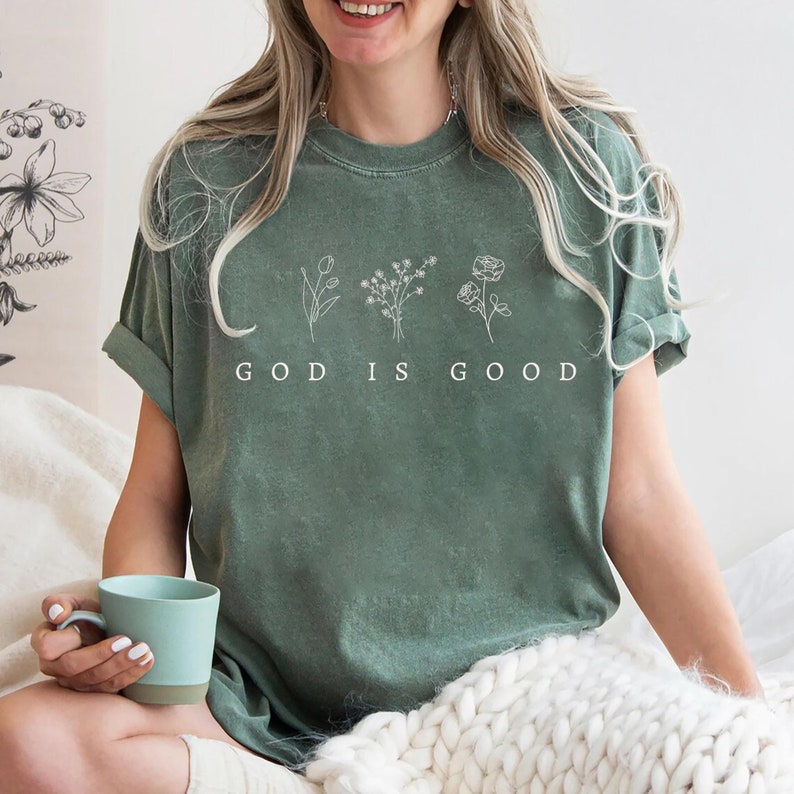 Trendy oversized Christian sweatshirt with God is Good text, faith apparel, perfect for spiritual retreats and religious events.