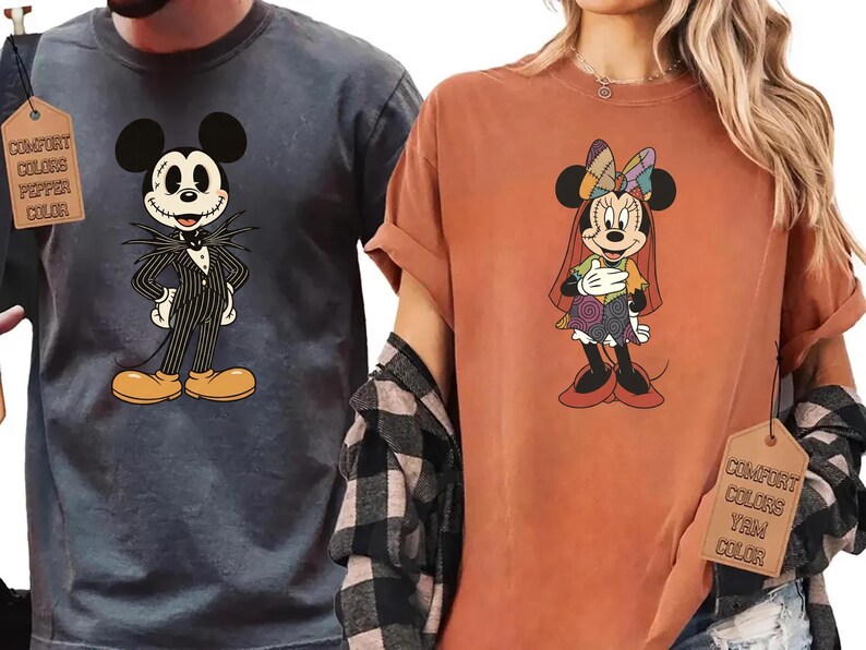 May include: Two t-shirts featuring cartoon characters. One is a dark gray shirt with Jack Skellington from The Nightmare Before Christmas. The other is a burnt orange shirt with Minnie Mouse in a Halloween costume. Both shirts have a tag that says "Comfort Colors".