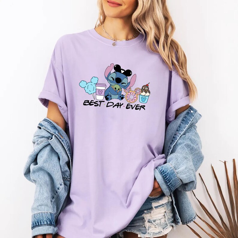 Stitch Best Day Ever Shirt featuring Stitch hugging Baby Yoda, surrounded by colorful Disney snacks like Mickey-shaped donuts, cotton candy, ice cream, and a Disney coffee cup. Cute and fun design perfect for a Disney Snacks Sweatshirt or T-shirt, great for Disney park trips, foodie gifts, and Stitch fans.