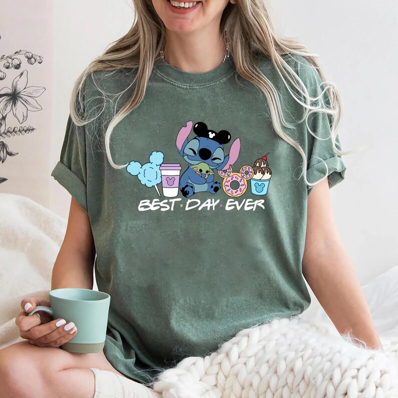 Stitch Best Day Ever Shirt featuring Stitch hugging Baby Yoda, surrounded by colorful Disney snacks like Mickey-shaped donuts, cotton candy, ice cream, and a Disney coffee cup. Cute and fun design perfect for a Disney Snacks Sweatshirt or T-shirt, great for Disney park trips, foodie gifts, and Stitch fans.