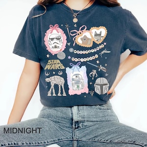 Retro pastel water color coquette Star Wars shirt with kawaii-style Stormtrooper, R2D2, AT-AT, Ewok, and Mandalorian helmet in watercolor frames with bows and hearts, perfect for Disney trip or Star Wars Day outfit.