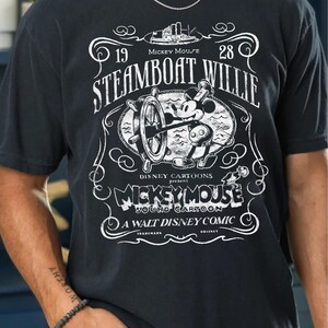 Vintage Steamboat Willie shirt featuring classic black and white Mickey Mouse steering a ship wheel, retro Disney cartoon design, perfect for Magic Kingdom trips, Disney family vacation outfits, or nostalgic Mickey Mouse birthday gifts for adults and kids.