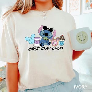 Stitch Best Day Ever Shirt featuring Stitch hugging Baby Yoda, surrounded by colorful Disney snacks like Mickey-shaped donuts, cotton candy, ice cream, and a Disney coffee cup. Cute and fun design perfect for a Disney Snacks Sweatshirt or T-shirt, great for Disney park trips, foodie gifts, and Stitch fans.