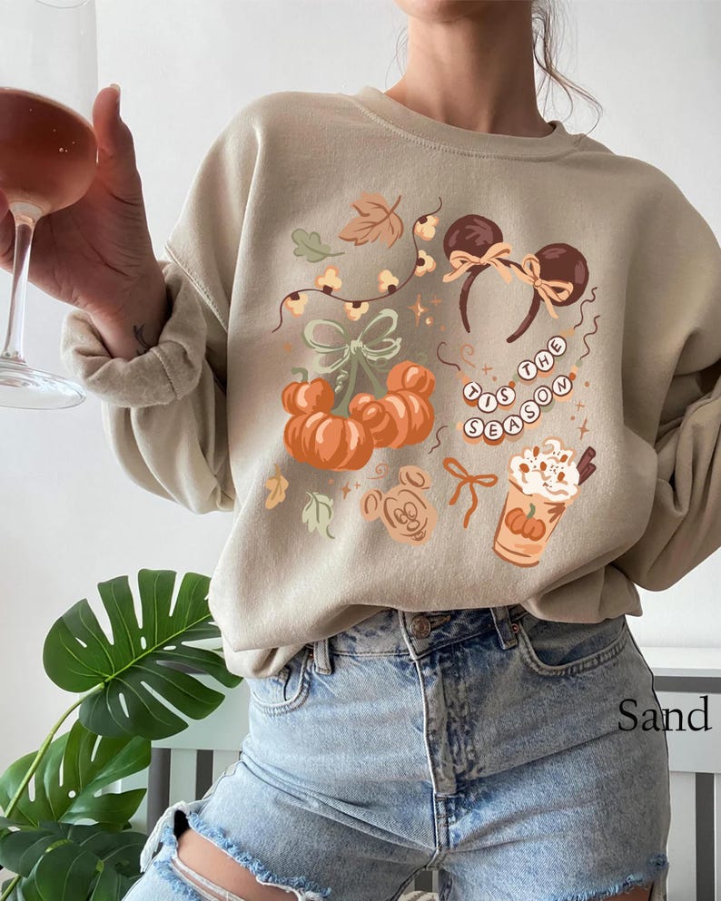 retro disney halloween shirt design featuring coquette bow mickey ears pumpkins fall leaves cozy autumn coffee cup tis the season beaded necklace and cute disney fall vibes illustration