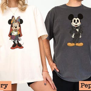 May include: Two oversized t-shirts, one ivory and one pepper, featuring cartoon character designs. The ivory shirt displays Minnie Mouse in a colorful patchwork outfit. The pepper shirt showcases Mickey Mouse dressed as Jack Skellington. The bottom of the image has the text "Ivory" and "Pepper".