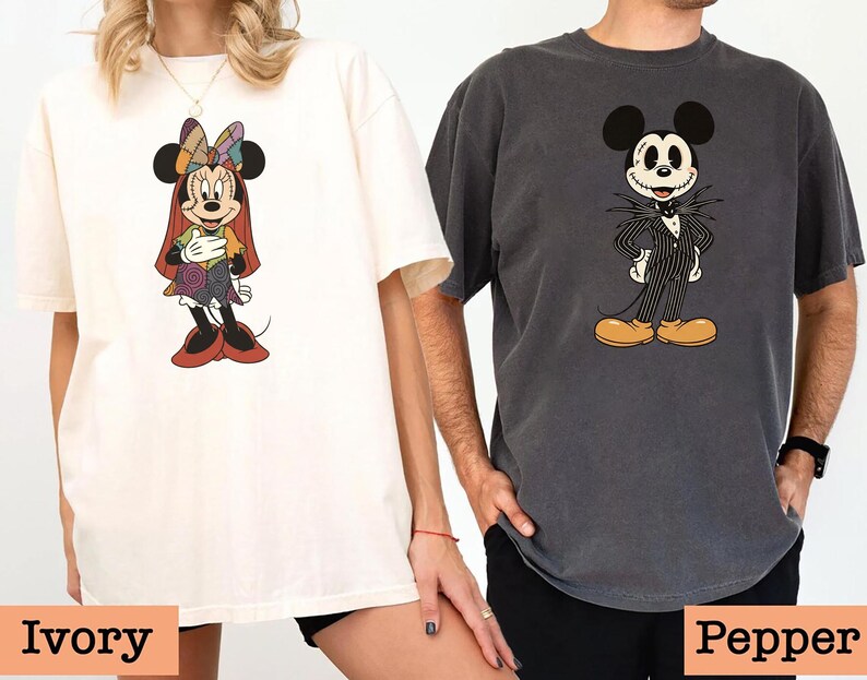 May include: Two oversized t-shirts, one ivory and one pepper, featuring cartoon character designs. The ivory shirt displays Minnie Mouse in a colorful patchwork outfit. The pepper shirt showcases Mickey Mouse dressed as Jack Skellington. The bottom of the image has the text "Ivory" and "Pepper".